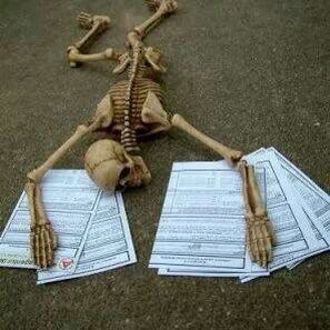 a skeleton laying on the ground with papers around it