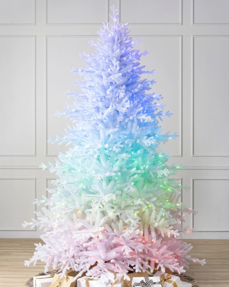 a multicolored christmas tree with presents under it