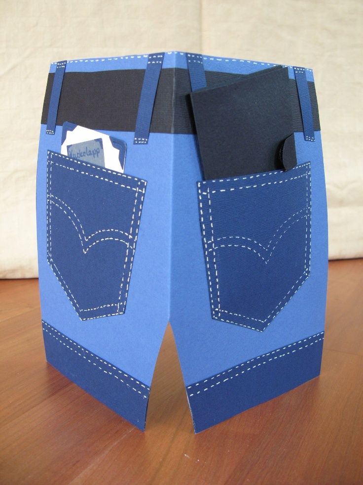 an origami box with two blue jeans in the pocket on top of it