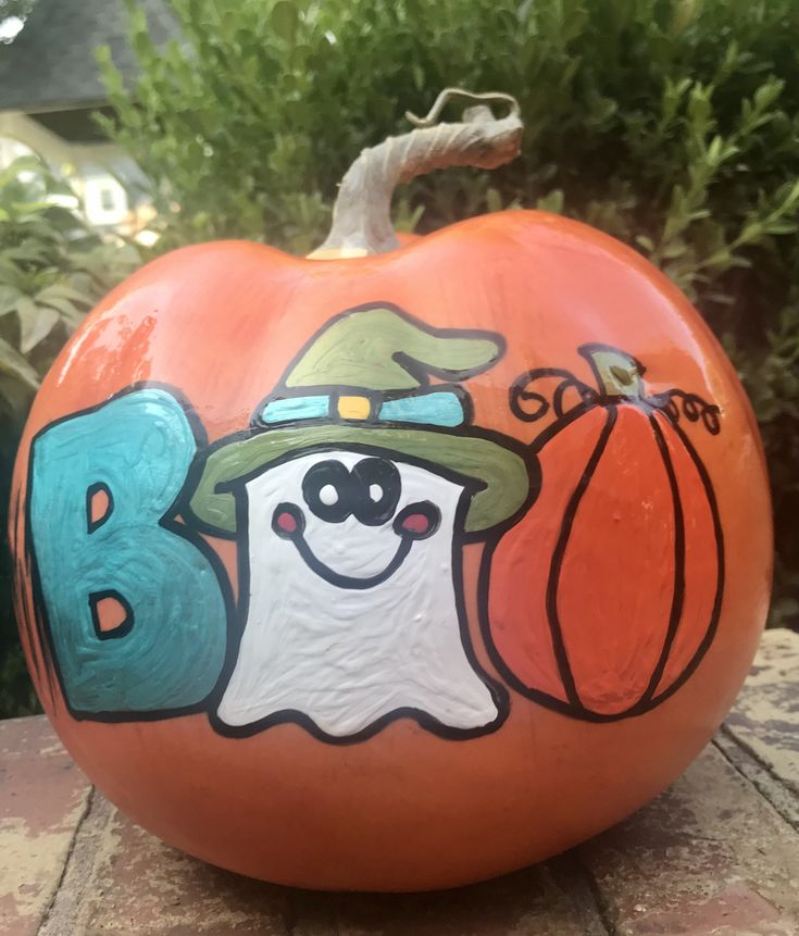 a painted pumpkin sitting on top of a wooden table