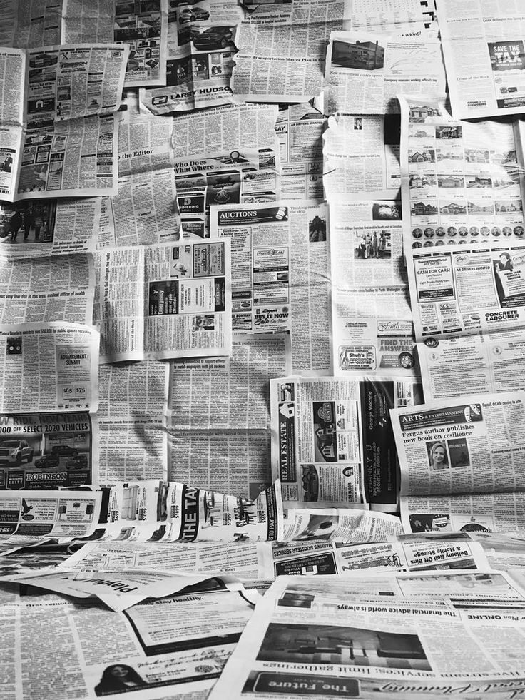 many newspapers are spread out on the table and scattered with papers in black and white