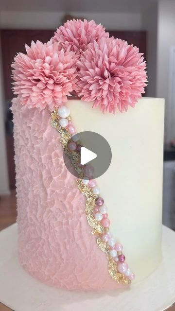 a white cake with pink flowers and pearls on it