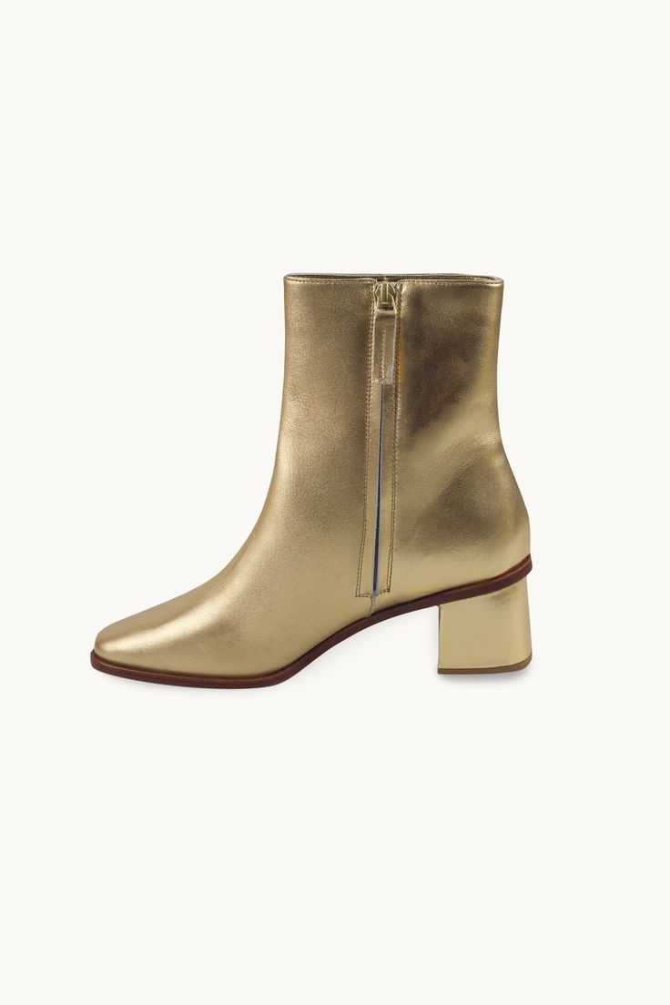 These ankle boots are crafted from high-quality leather in a metallic gold hue. They feature a side zipper closure, a low heel, and a sleek design. Designed for a bold and stylish look. Use our virtual size assistant to find your perfect fit. Gold Leather Ankle Heeled Boots, Gold Ankle Leather Heeled Boots, Chic Gold Leather Boots, Gold Ankle Boots For Fall, Metallic Ankle Boots For Fall, Gold Leather Chic Heeled Boots, Chic Gold Leather Heeled Boots, Chic Gold Heeled Boots For Fall, Chic Metallic Heeled Boots For Fall