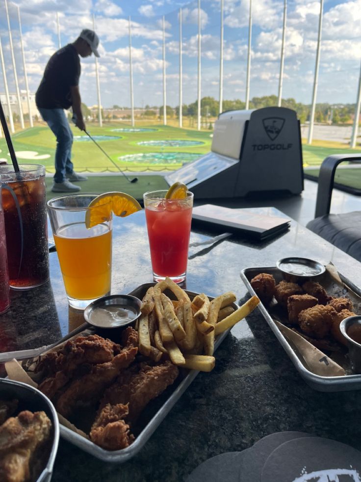 a table topped with trays of food and drinks