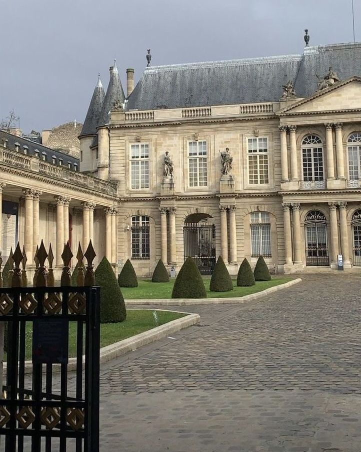 a large building with lots of windows next to a gate