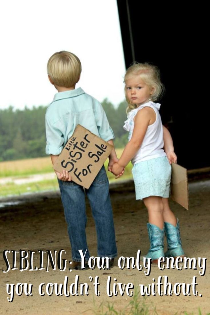 two young children holding hands and standing in front of a barn