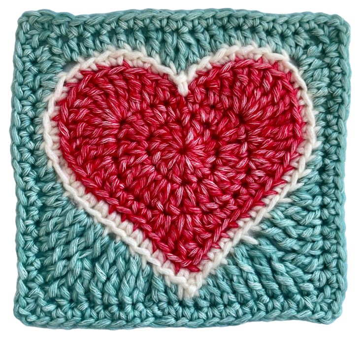 a crocheted square with a red heart on it