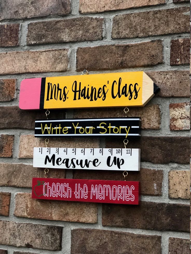 a wooden sign hanging on the side of a brick building that says mrs haine's class