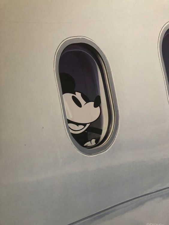 an airplane window with mickey mouse stickers on it