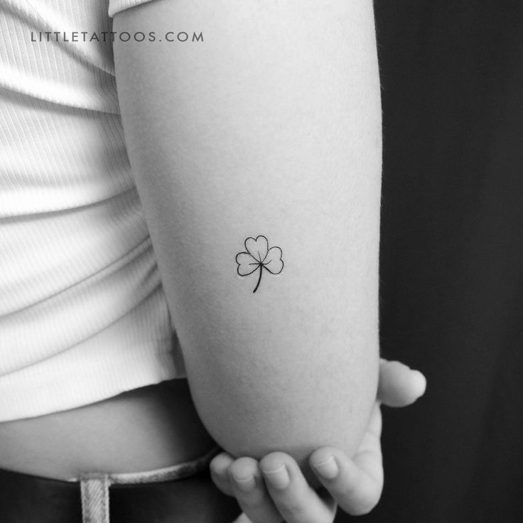 a small four leaf clover tattoo on the arm