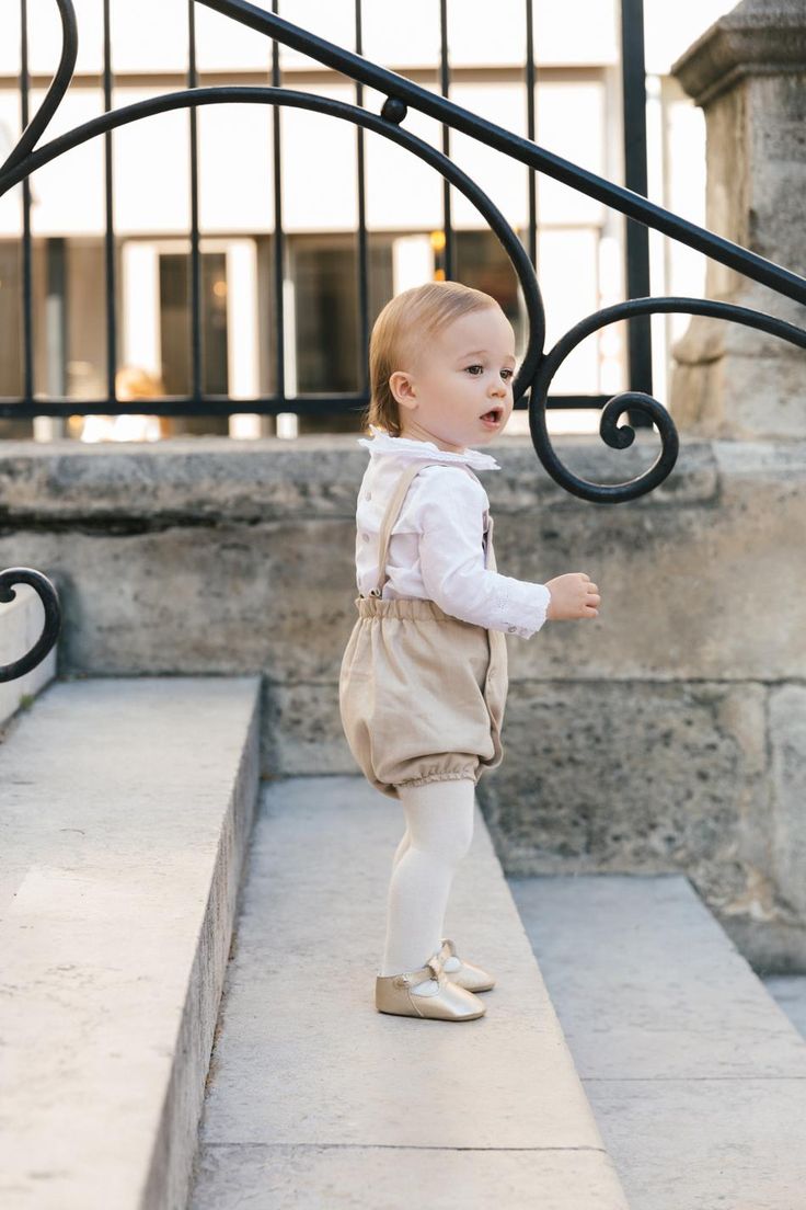 a small child is standing on the steps and looking at something in front of him