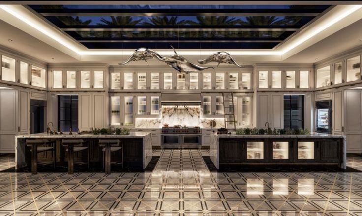 a large kitchen with marble flooring and white cabinetry is lit by recessed lights