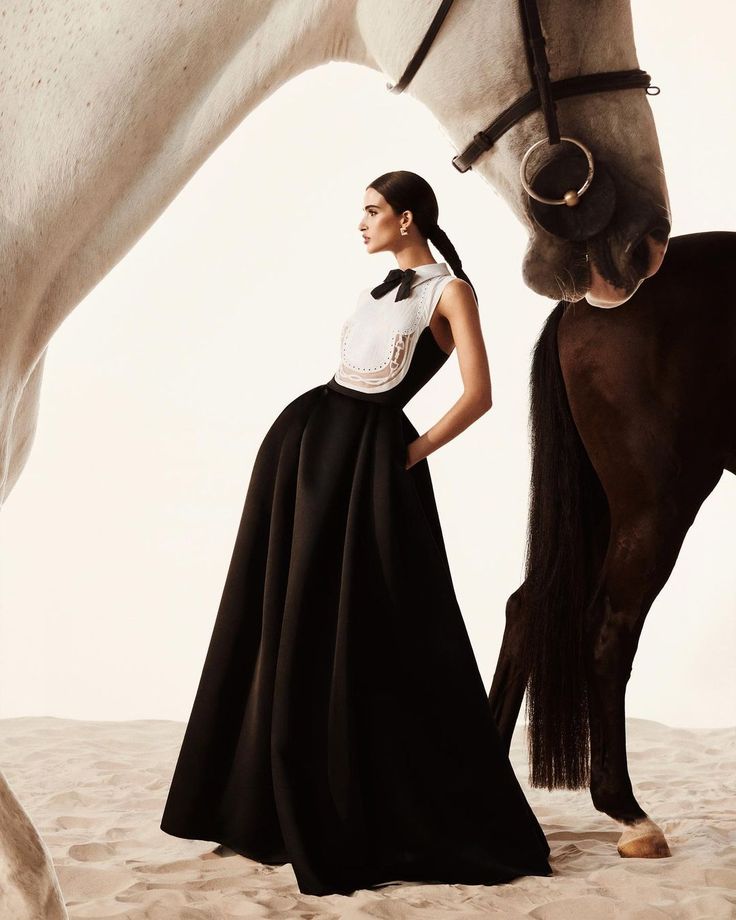 a woman is standing next to a horse