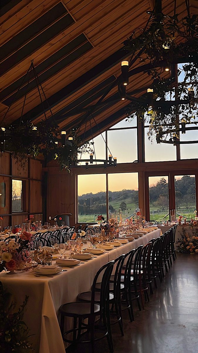 a long table is set up in the middle of a large room with lots of windows