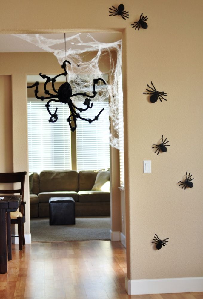 a living room filled with furniture and spider webs on the wall next to a dining table