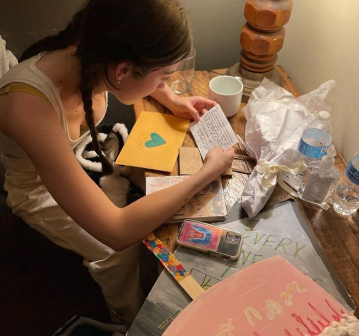 a woman sitting at a table with some cards and papers on top of her desk