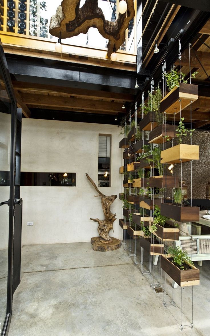 an indoor space with several planters on the wall and a sculpture in the center