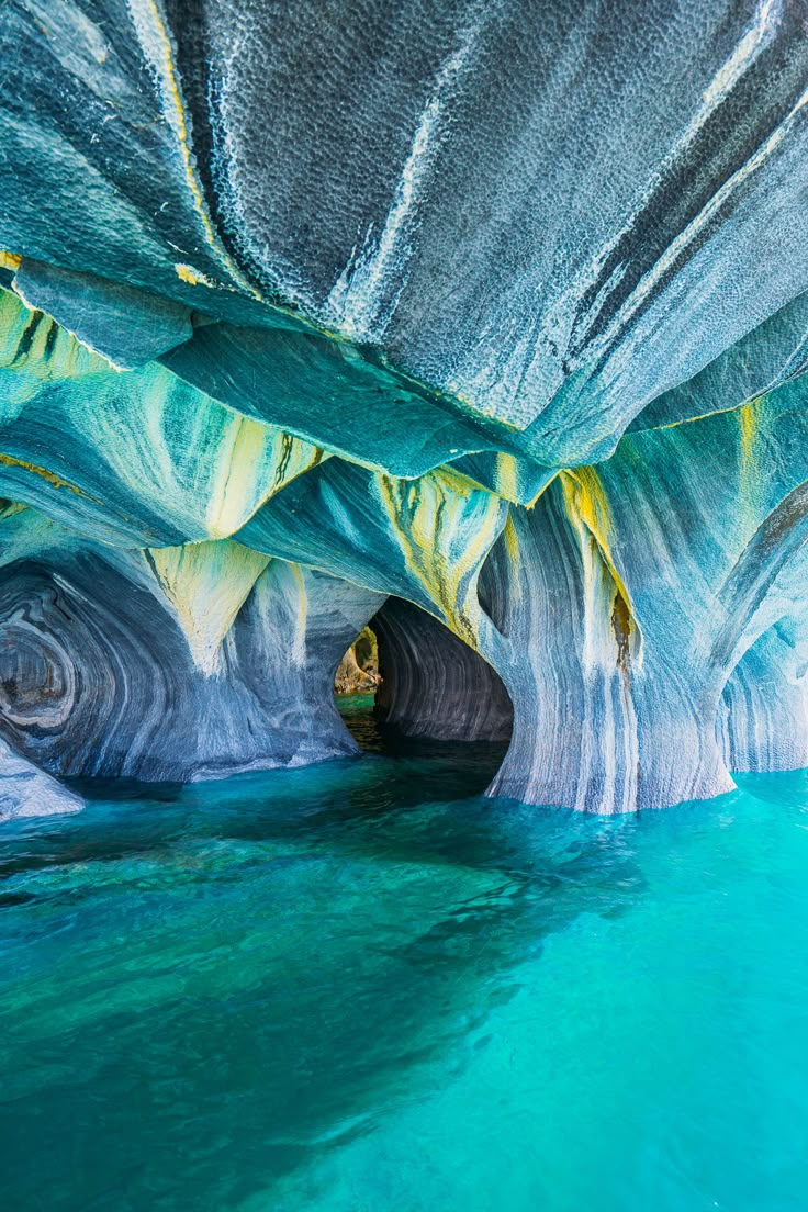 the inside of a cave with blue water