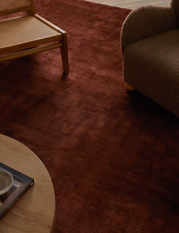 a living room filled with furniture and a coffee table in front of a chair on top of a rug