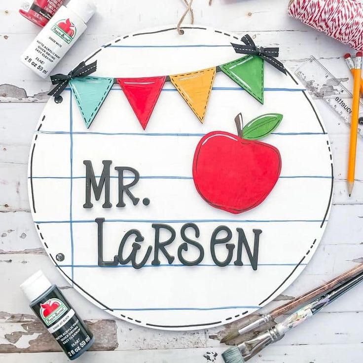 a sign with an apple on it that says mr larsen and is surrounded by craft supplies