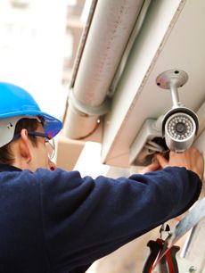 a man wearing a hard hat and safety goggles is fixing an air conditioner