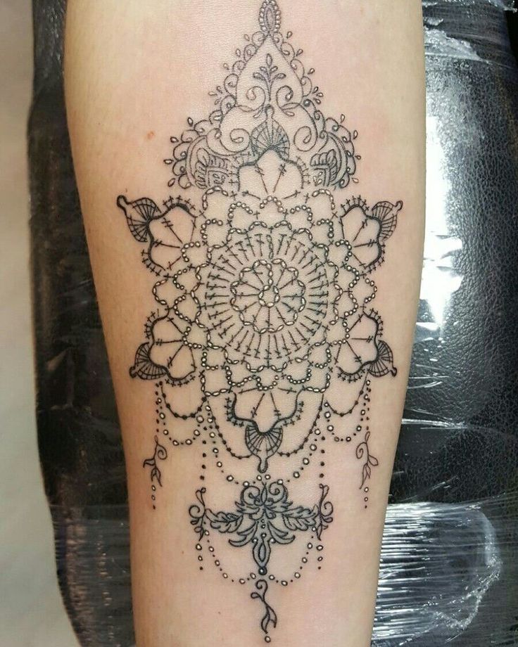 a black and white photo of a tattoo on the leg, with an intricate design