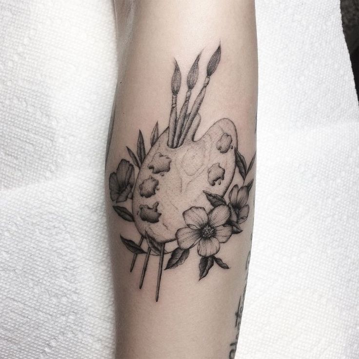 a black and white photo of flowers on the arm, with an arrow in the center