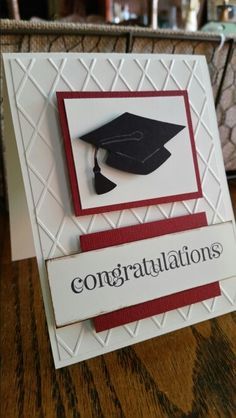 congratulations card with graduation cap and tasseled ribbon on the front, sitting on a wooden table