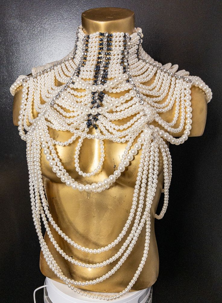 The pearl and rhinestone statement necklace is a stunning piece of jewelry that is sure to make a bold impression. The necklace features a combination of pearls and rhinestones, which create a striking contrast and add a touch of glamour and sophistication to any outfit. It's perfect for formal events and can be worn with a variety of different outfits, from dresses to blouses and even t-shirts. This necklace is truly a statement piece that is sure to turn heads wherever you go! Pearl White Pearl Necklaces For Party, Party Pearl Necklace With Pearl Pendant, Pearl Drop Costume Jewelry Necklaces For Party, Costume Jewelry Pearl Drop Necklaces For Party, Pearl Drop Costume Jewelry Necklace For Party, Glamorous Pearl White Jewelry With Pearl Chain, Party Pearl Beaded Necklace With Pearl Pendant, Party Pearl Beaded Necklaces With Pearl Pendant, Party Crystal Necklace With Pearl Pendant