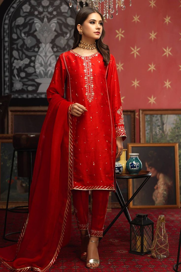 'Rahma' is an appealing red ensemble crafted with ivory embroidery, glittering with delicate kora, dabka, zarri and gotta work on the long neckline and sleeves with hand embroidered motifs. The pk raw silk shirt is paired with two toned dupatta that is terracotta and red with finishing lace on four sides making it a pe Sunnia Manahil, Indian Designer Suits, Pakistani Fashion Party Wear, Salwar Kamiz, Designer Party Wear Dresses, Embroidery Suits Design, Embroidery Designs Fashion, Pakistani Dress Design, Embroidery Suits