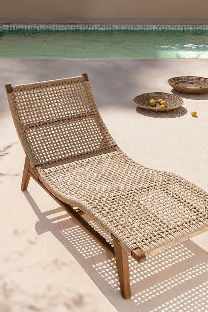 a lounge chair sitting on top of a sandy beach