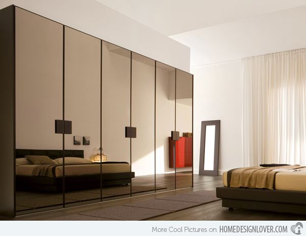 a bedroom with mirrored walls and a bed