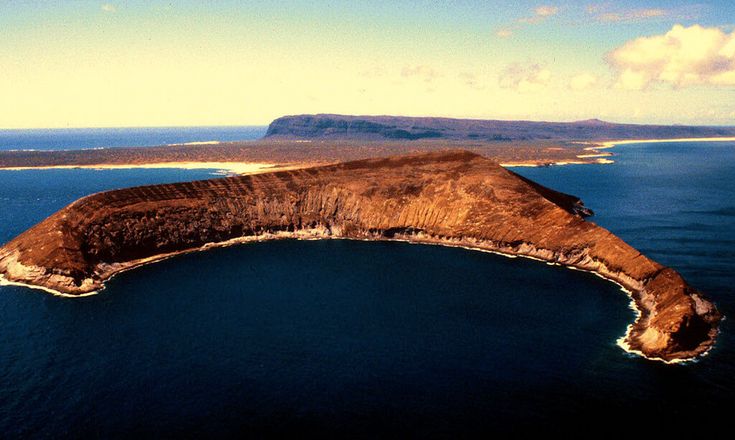 an island in the middle of the ocean with water around it and land on one side