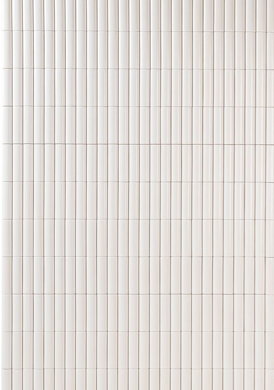 a white tiled wall with vertical lines on it