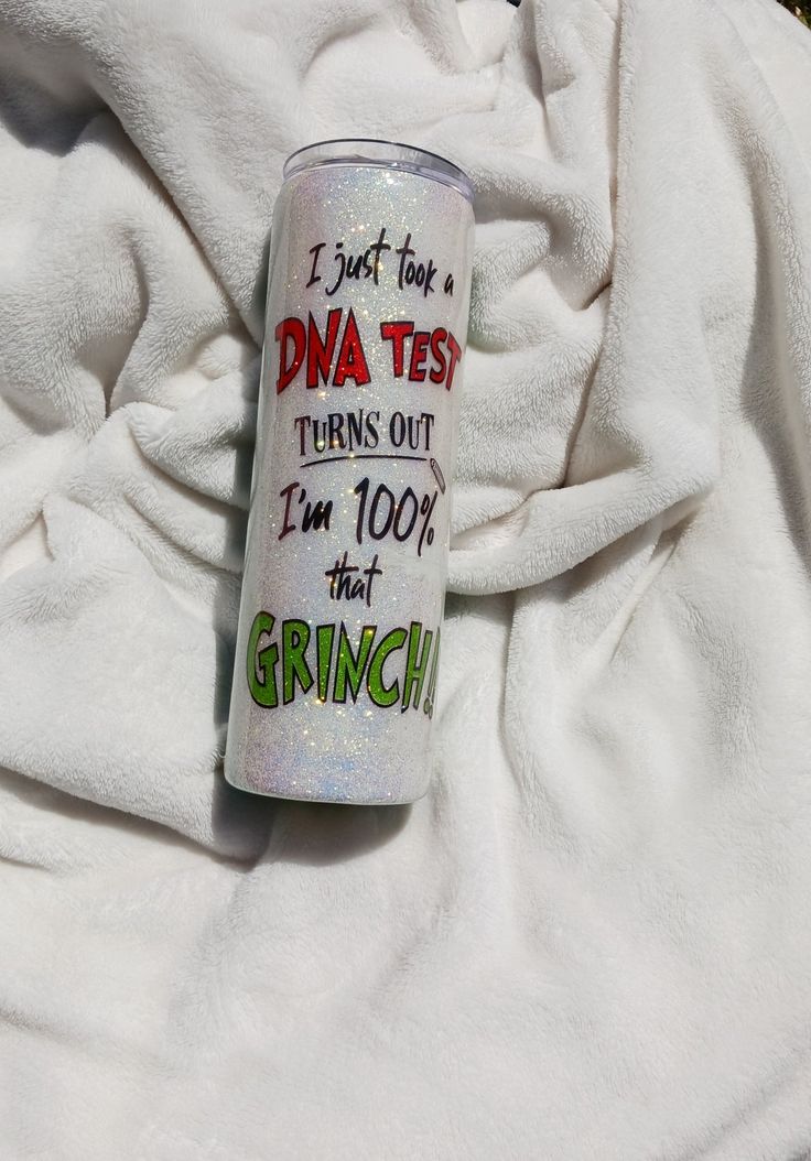 a can of drink sitting on top of a white towel covered in green and red writing