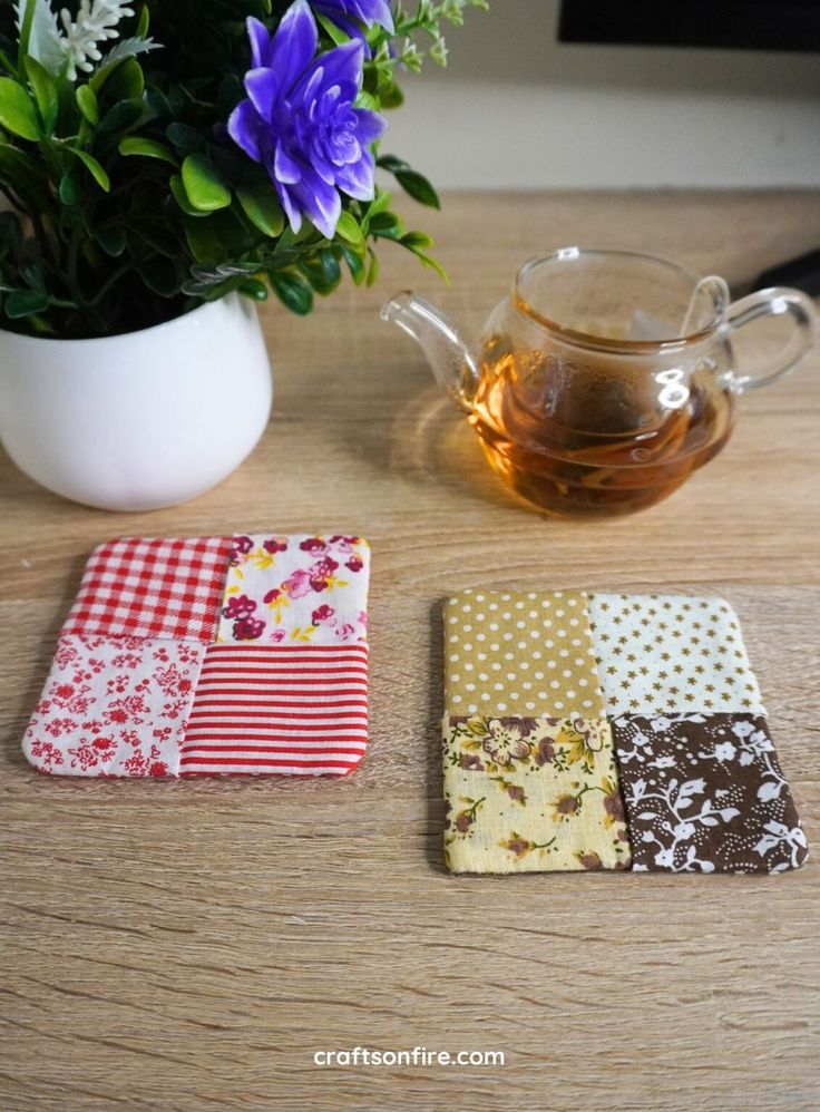 three coasters on a table next to a potted plant and a teapot