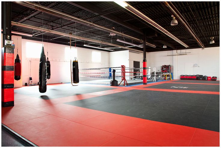 an empty gym with boxing gloves and punching bags