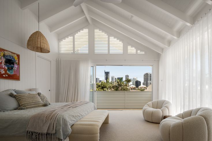 a bedroom with white walls and ceilings has a large window