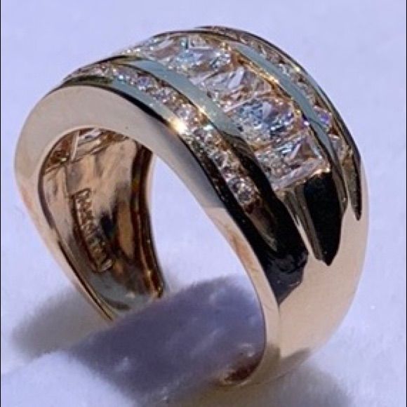 a gold ring with three rows of diamonds on it