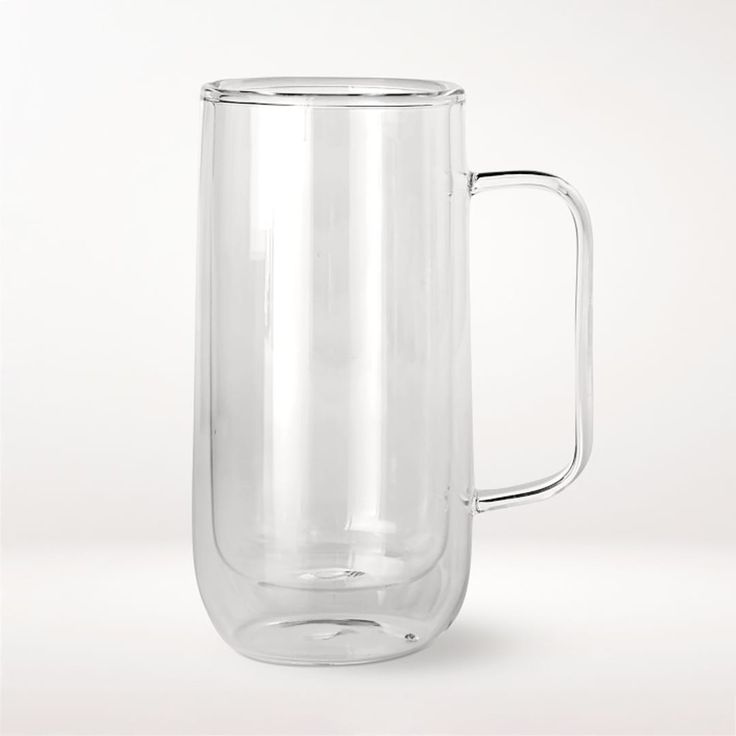 a clear glass mug with a handle on the side is sitting in front of a white background