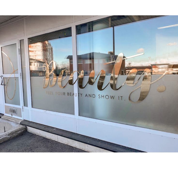 the front window of a beauty and show shop with reflection of buildings in it's windows