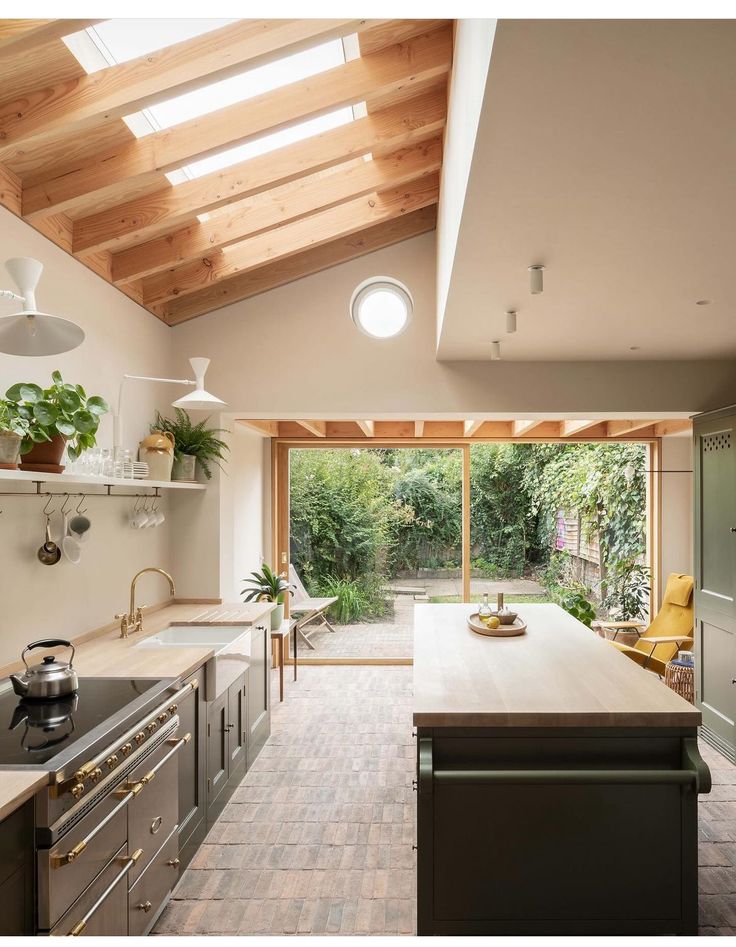 an open kitchen and dining area with skylights above the countertop, along with potted plants on shelves