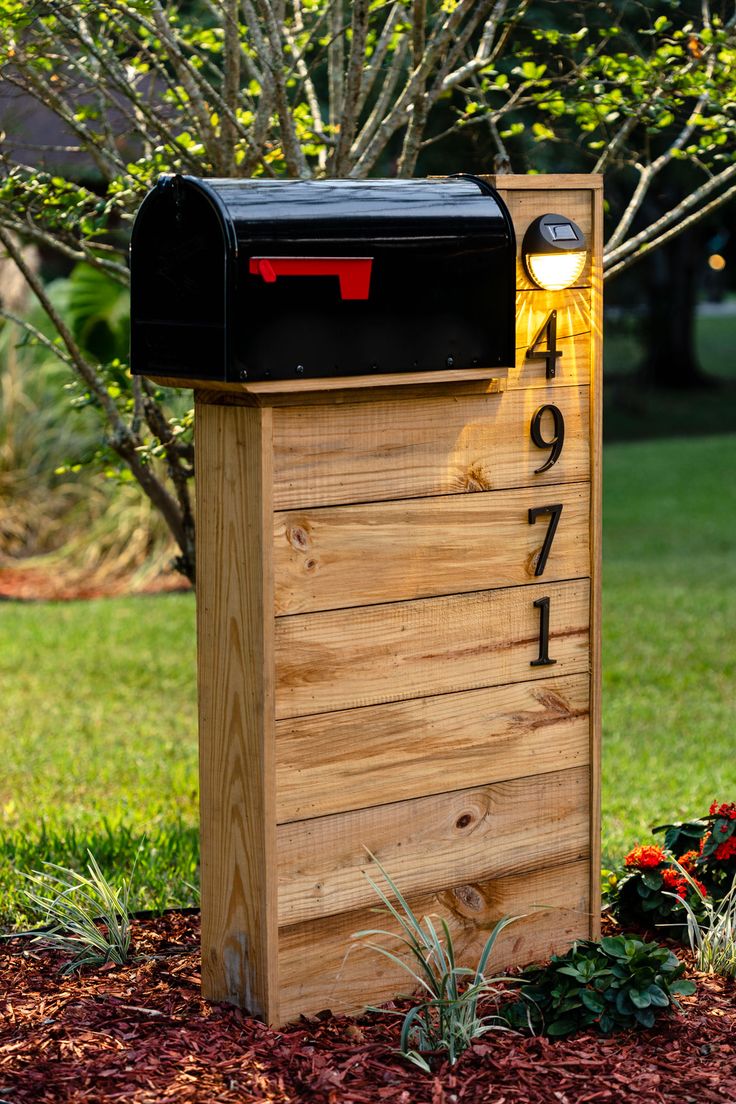 a wooden box with a light on it in the grass