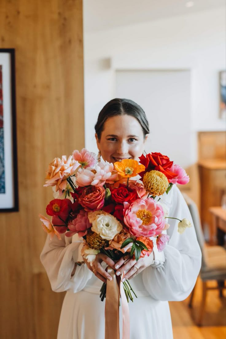 a woman holding a bouquet of flowers in her hands