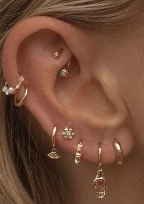 a close up of a person's ear with different types of piercings on it