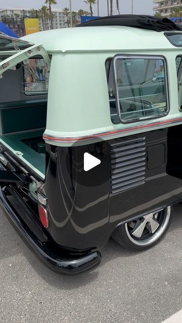 an old green and black truck parked in a parking lot