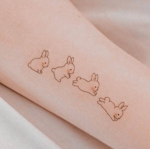 three little bunnies on the side of a woman's arm