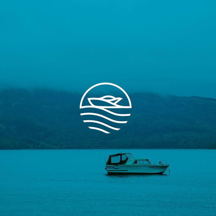 a boat floating on top of a lake under a blue sky with mountains in the background