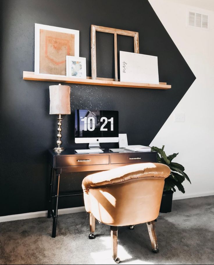 a desk with a chair and pictures on the wall