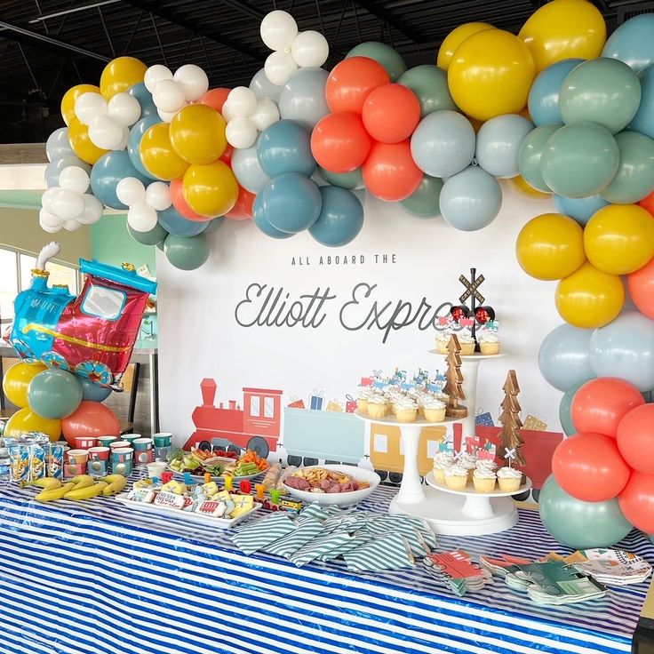 a train themed birthday party with balloons and desserts